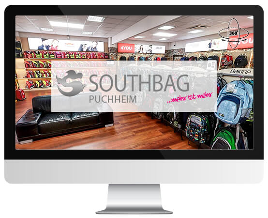 Auf einem Monitor ist die Innenansicht von Southbag Puchheim mit Rucksäcken und dem Slogan "...mehr ist mehr" zu sehen.